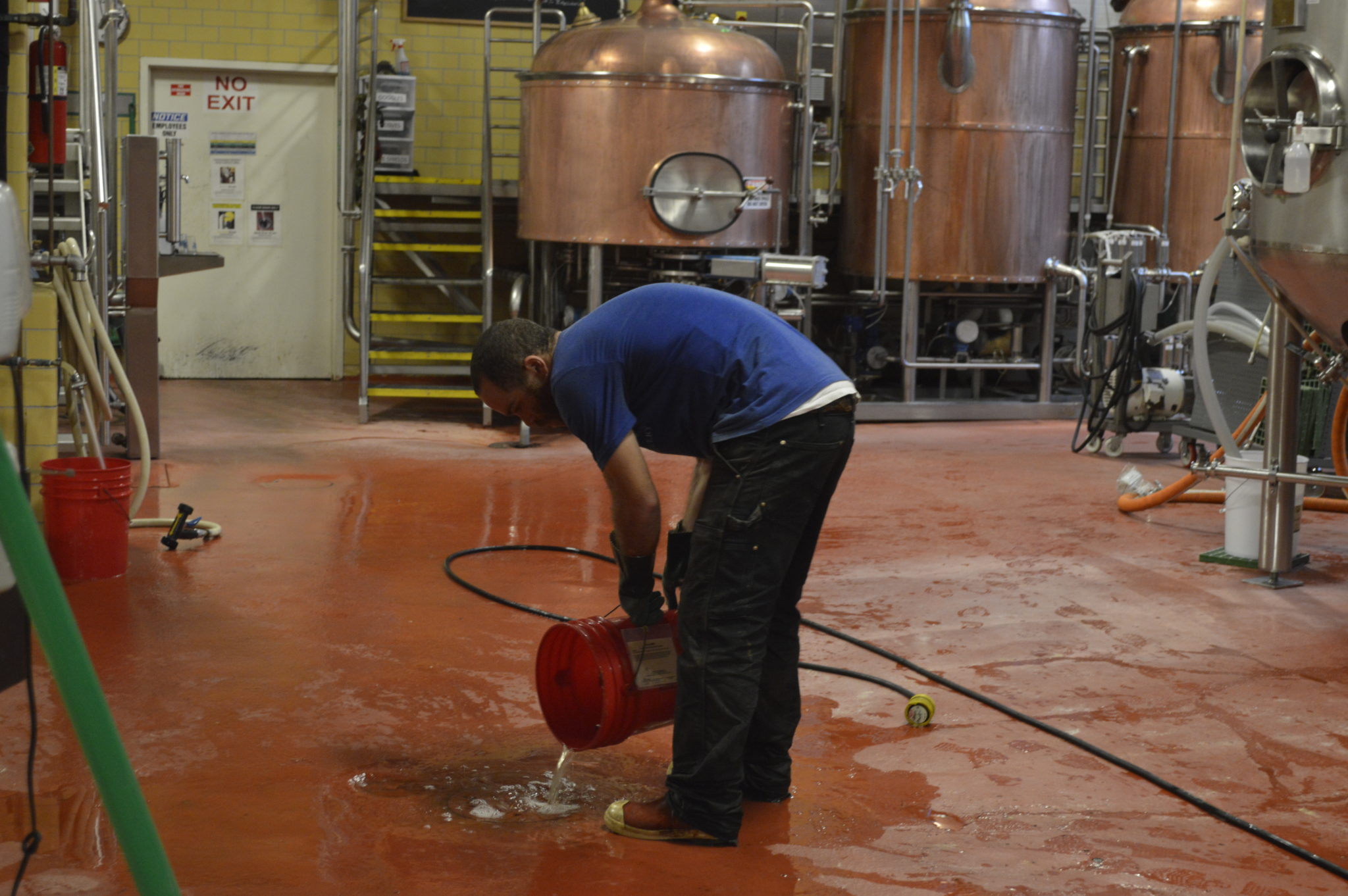 Photograph of a worker cleaning the machinery Inside the Samuel Adams brewery
